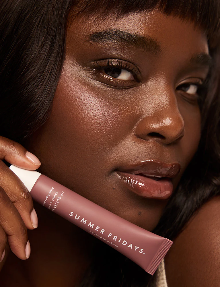 Woman holding a 'Summer Fridays' lip balm close to her face